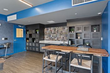 A blue kitchen with a wooden table and chairs.